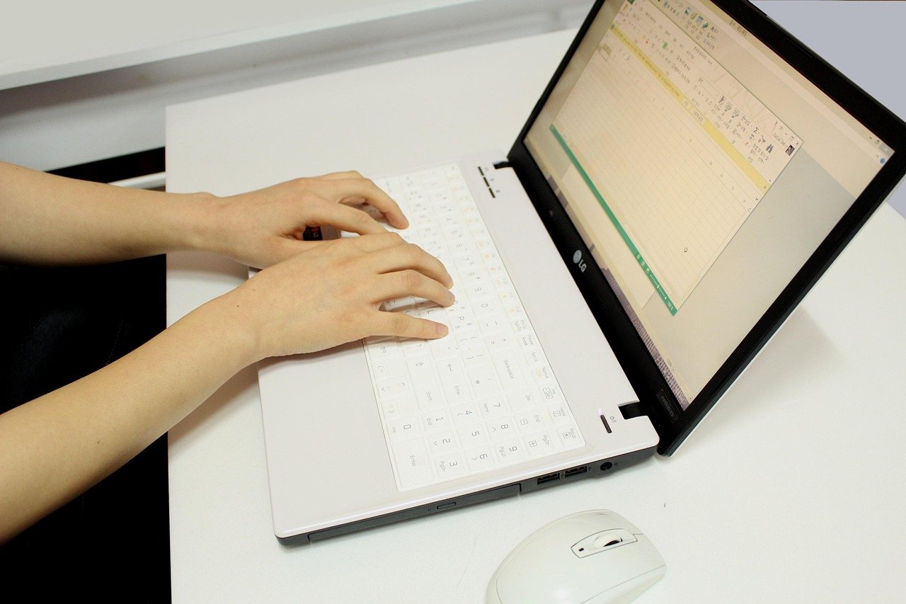 Home Overhead view of hands typing on a laptop