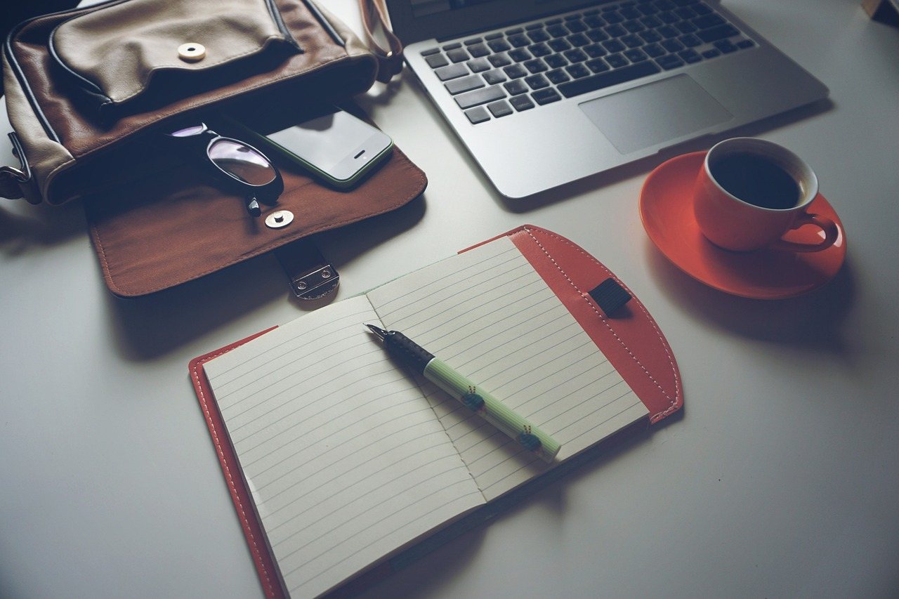 Home Desk from above with laptop, notebook and coffee