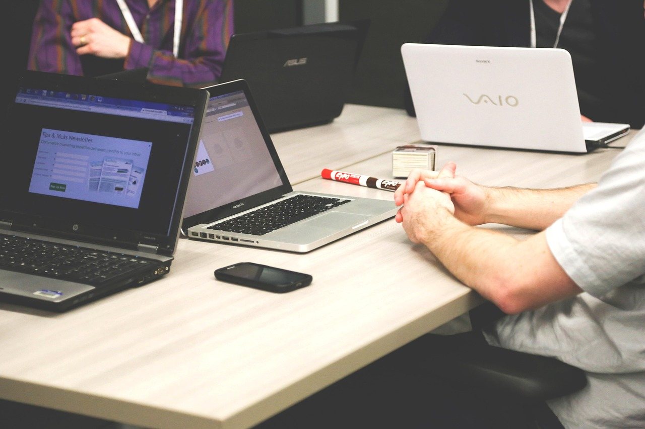 Home Two colleagues working on laptops at a desk